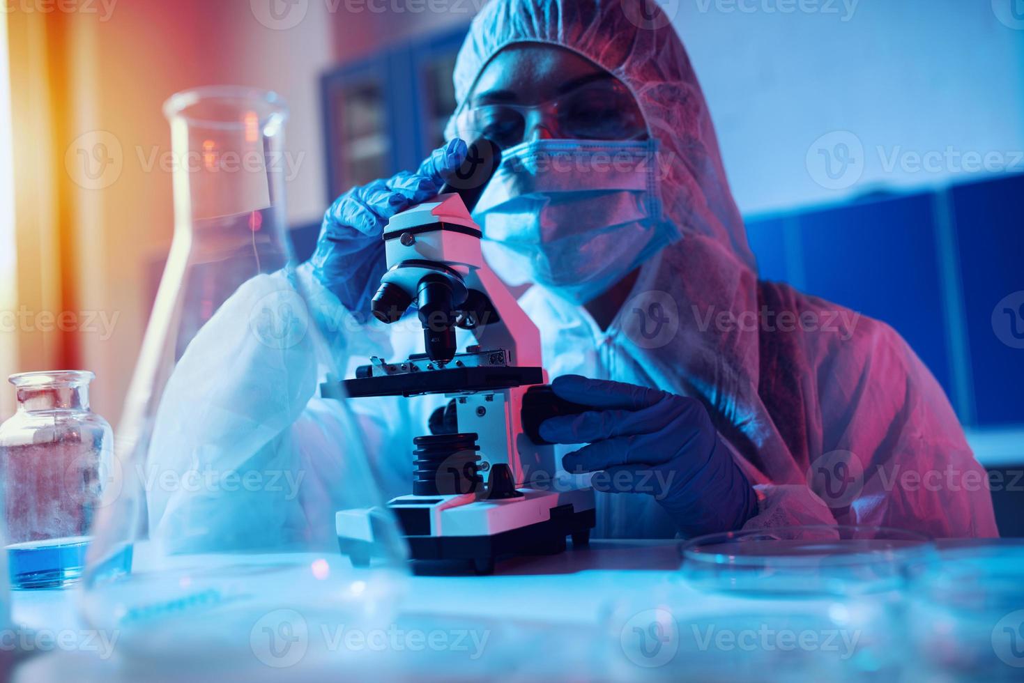médico en el laboratorio análisis muestras debajo un microscopio. farmacéutico tratamiento concepto. foto