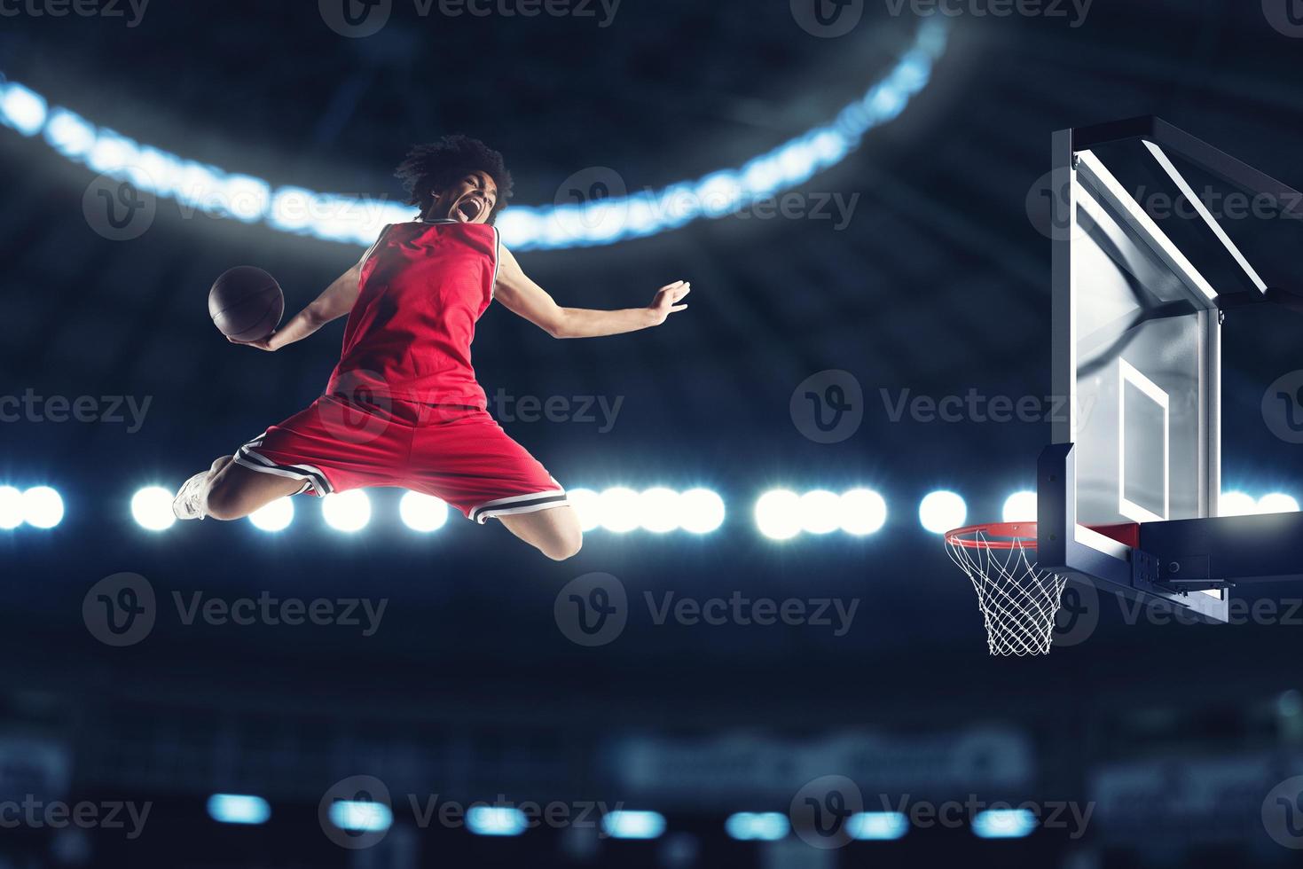 Acrobatic slam dunk of a basket player in the basket at the stadium photo