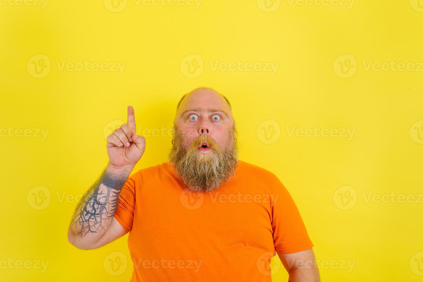 Amazed man with beard and tattoos is amazed about something photo