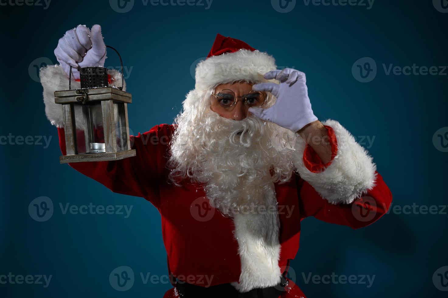 Doubtful santa claus with a vintage lantern photo