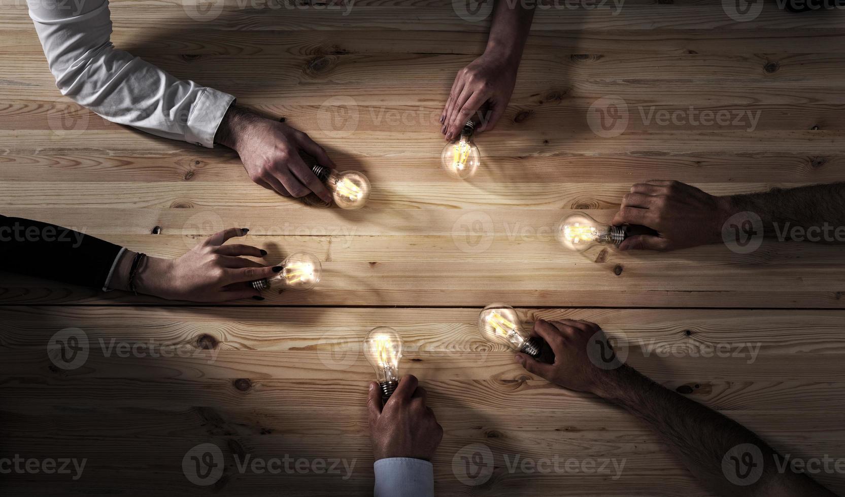 Teamwork and brainstorming concept with businessmen that share an idea with a lamp. Concept of startup photo
