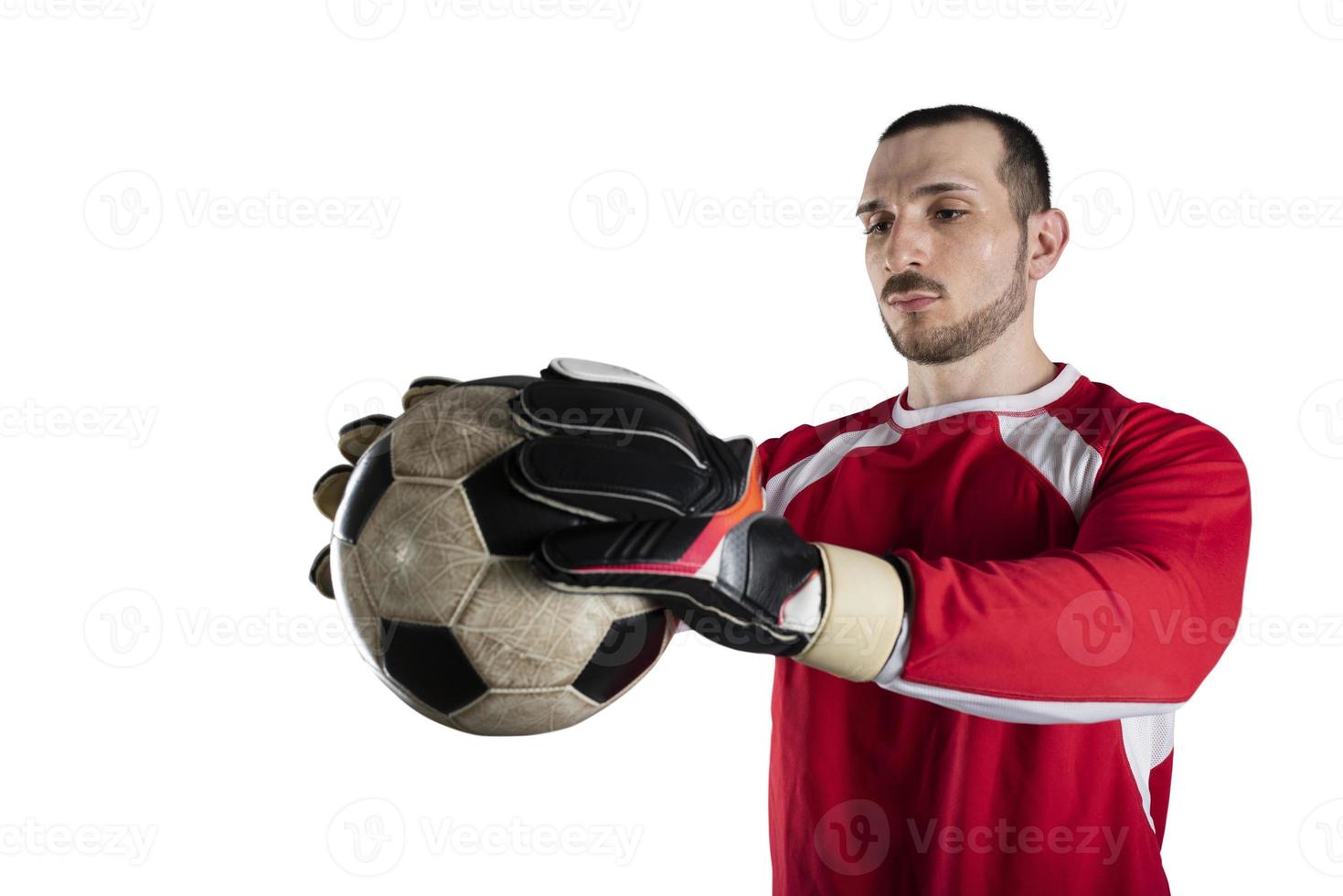 Goalkeeper holds the ball in the stadium during a football game. Isolated on white background photo