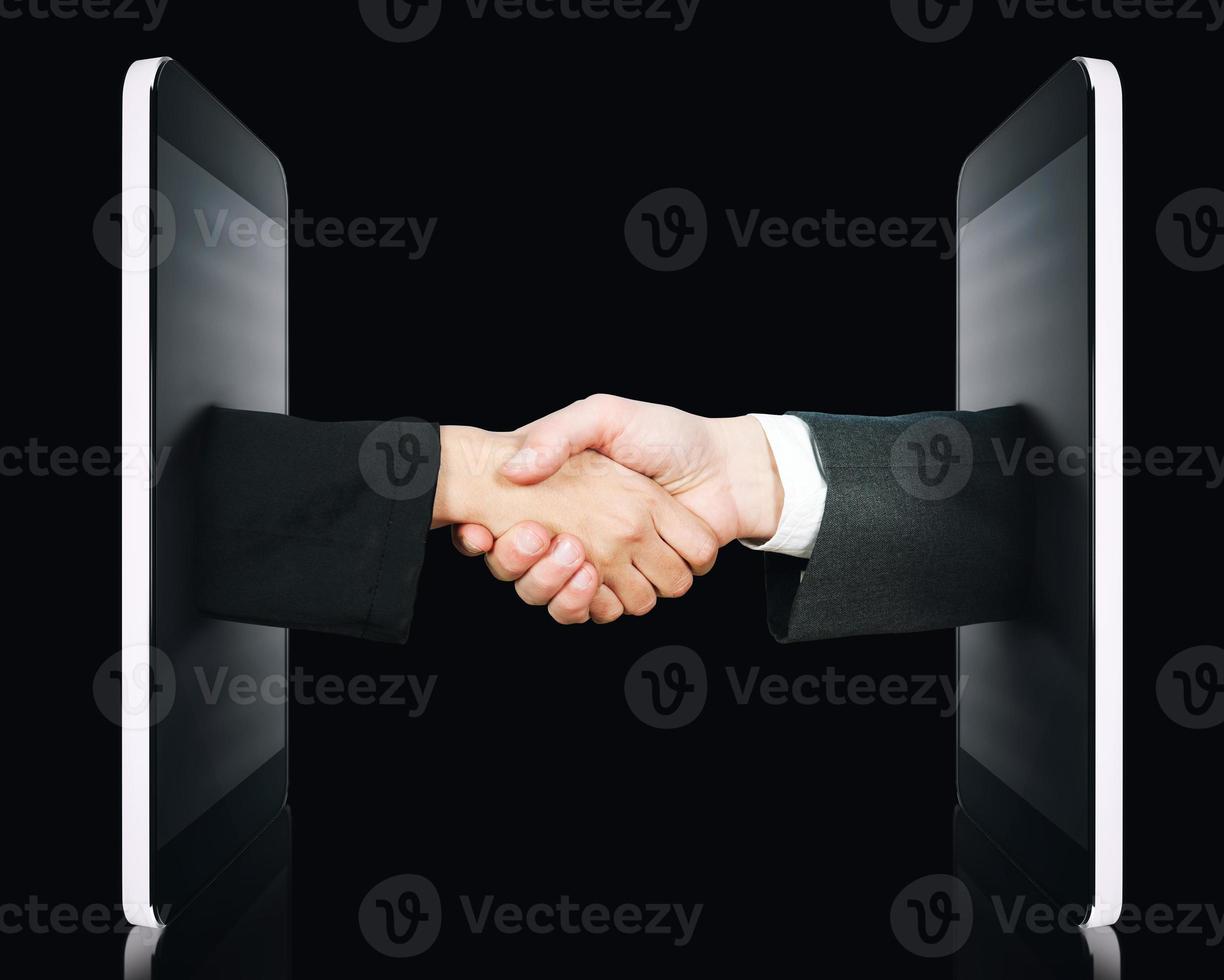 Hands comes out of the screen to sign an agreement or to know each other photo