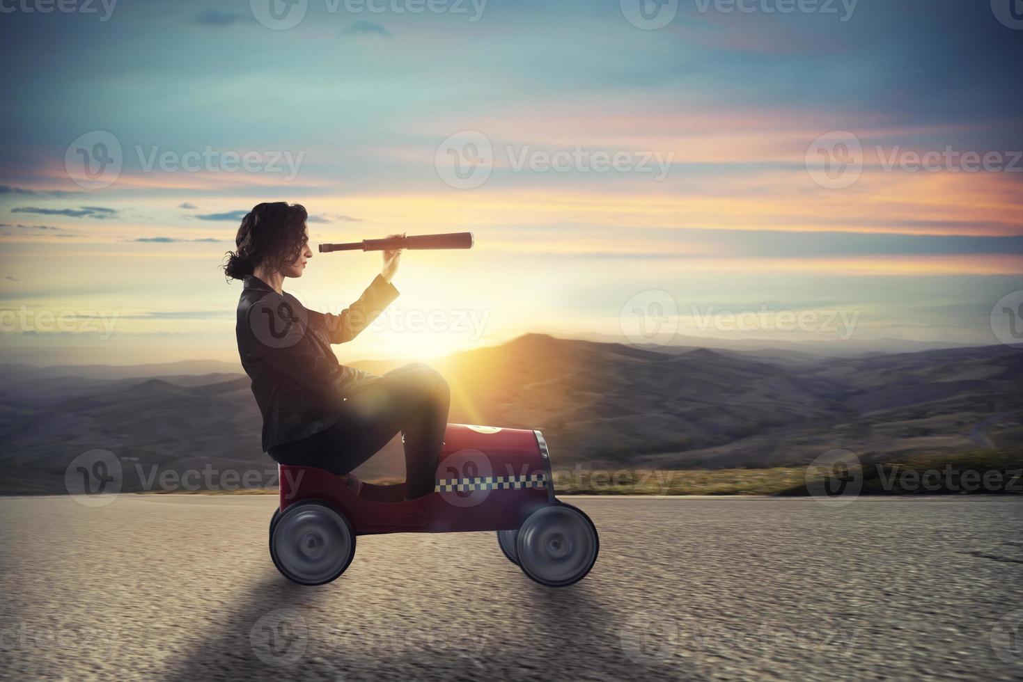 Businesswoman with telescope on a car looks for new business opportunity photo