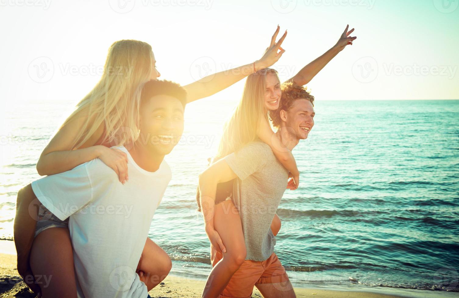 Happy smiling couples playing at the beach photo