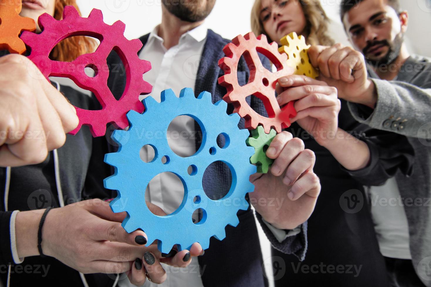 Business team connect pieces of gears. Teamwork, partnership and integration concept photo
