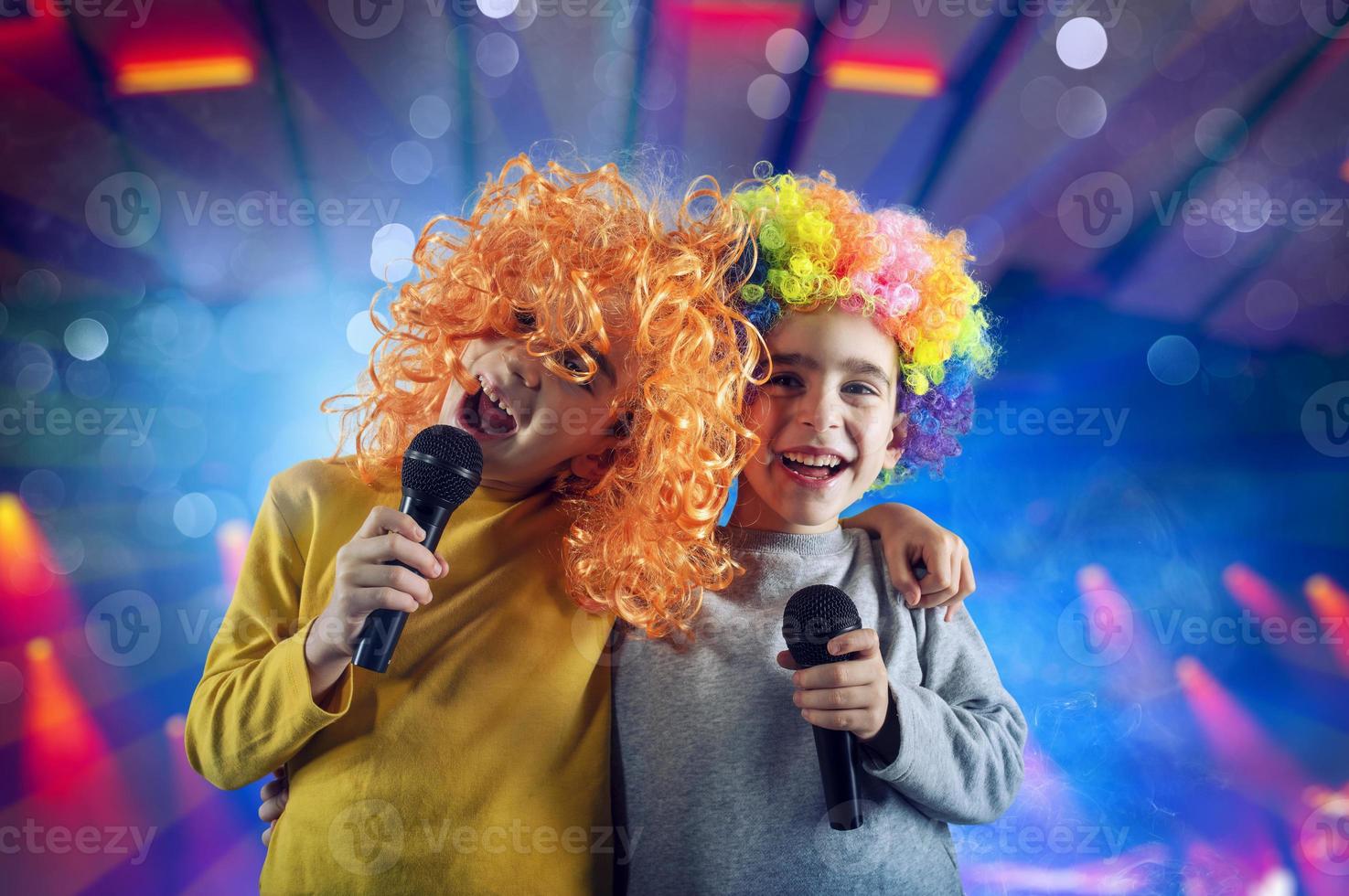 Two child sing a song with microphone and funny wig photo