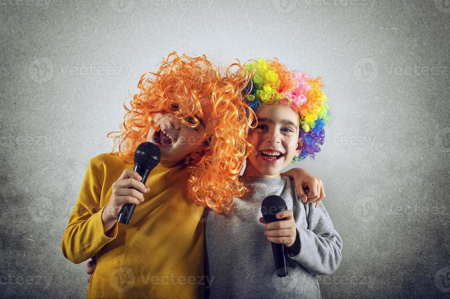 Two child sing a song with microphone and funny wig photo