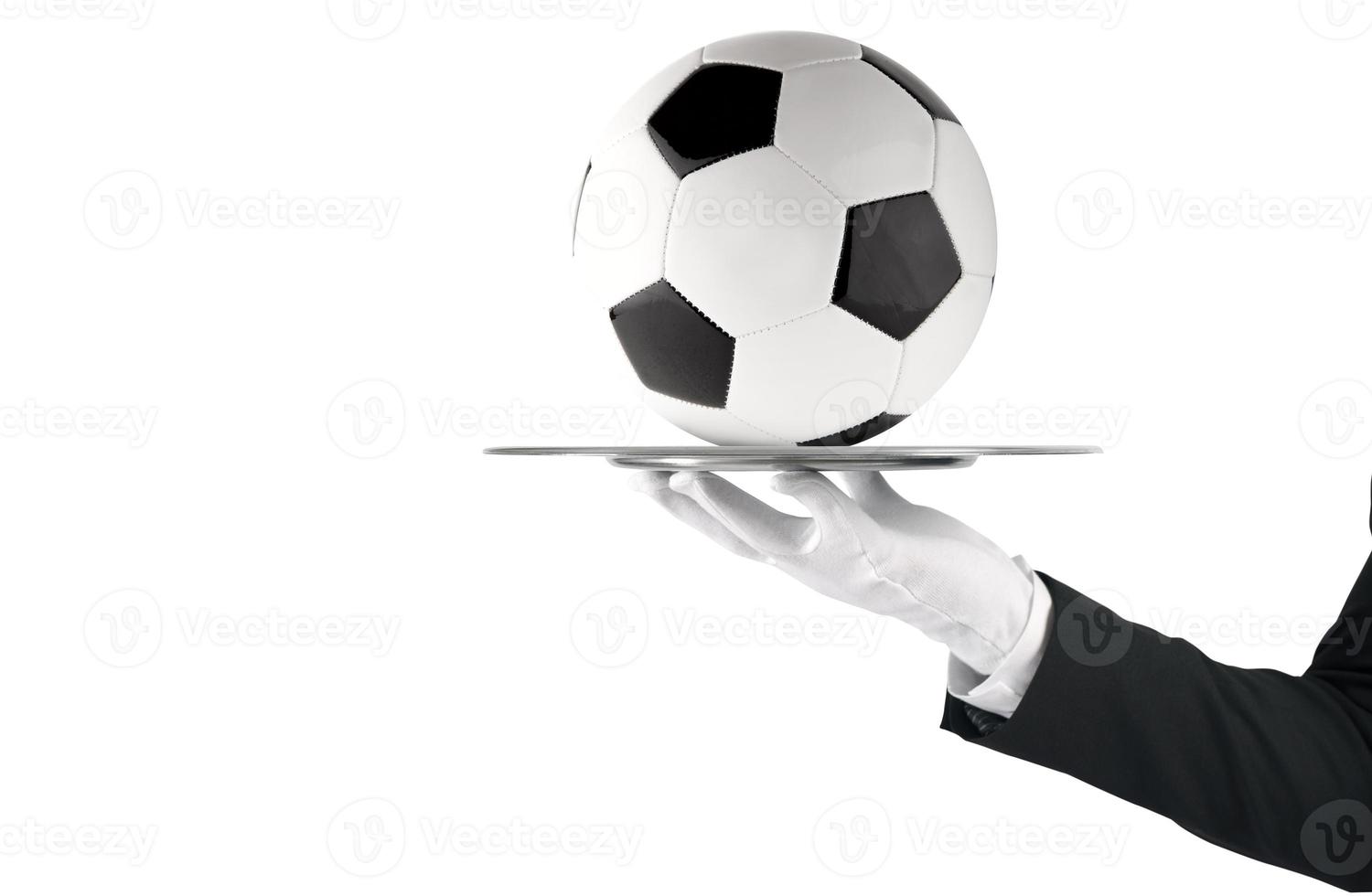 Waiter that holds a tray with soccer ball. Concept of first class service on soccer photo