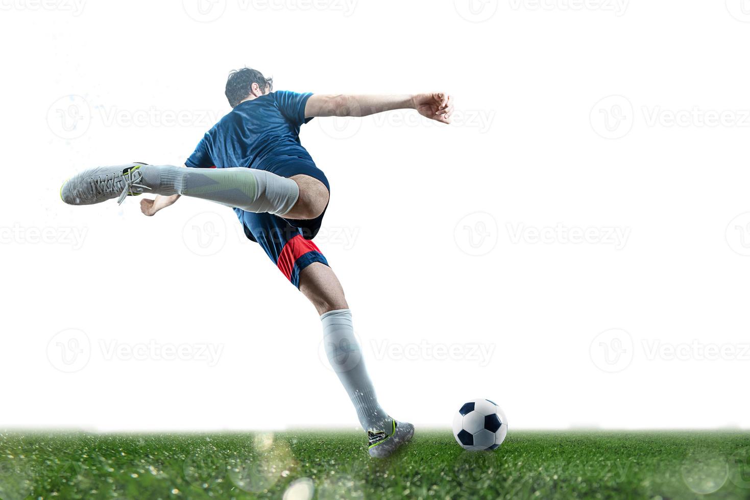 Football scene at night match with player kicking the ball with power. photo