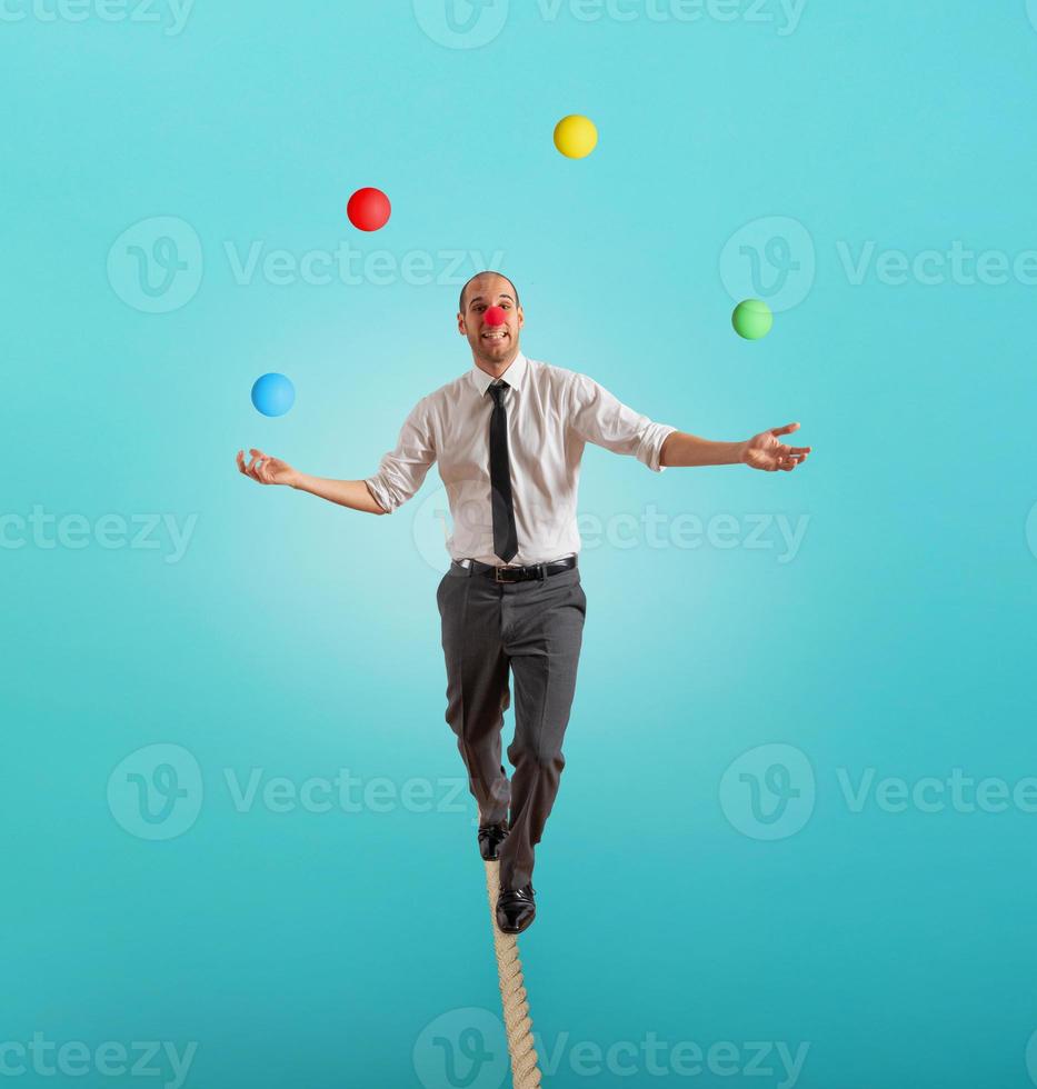 Worry man in balance walking on a rope overand acts like a juggler photo