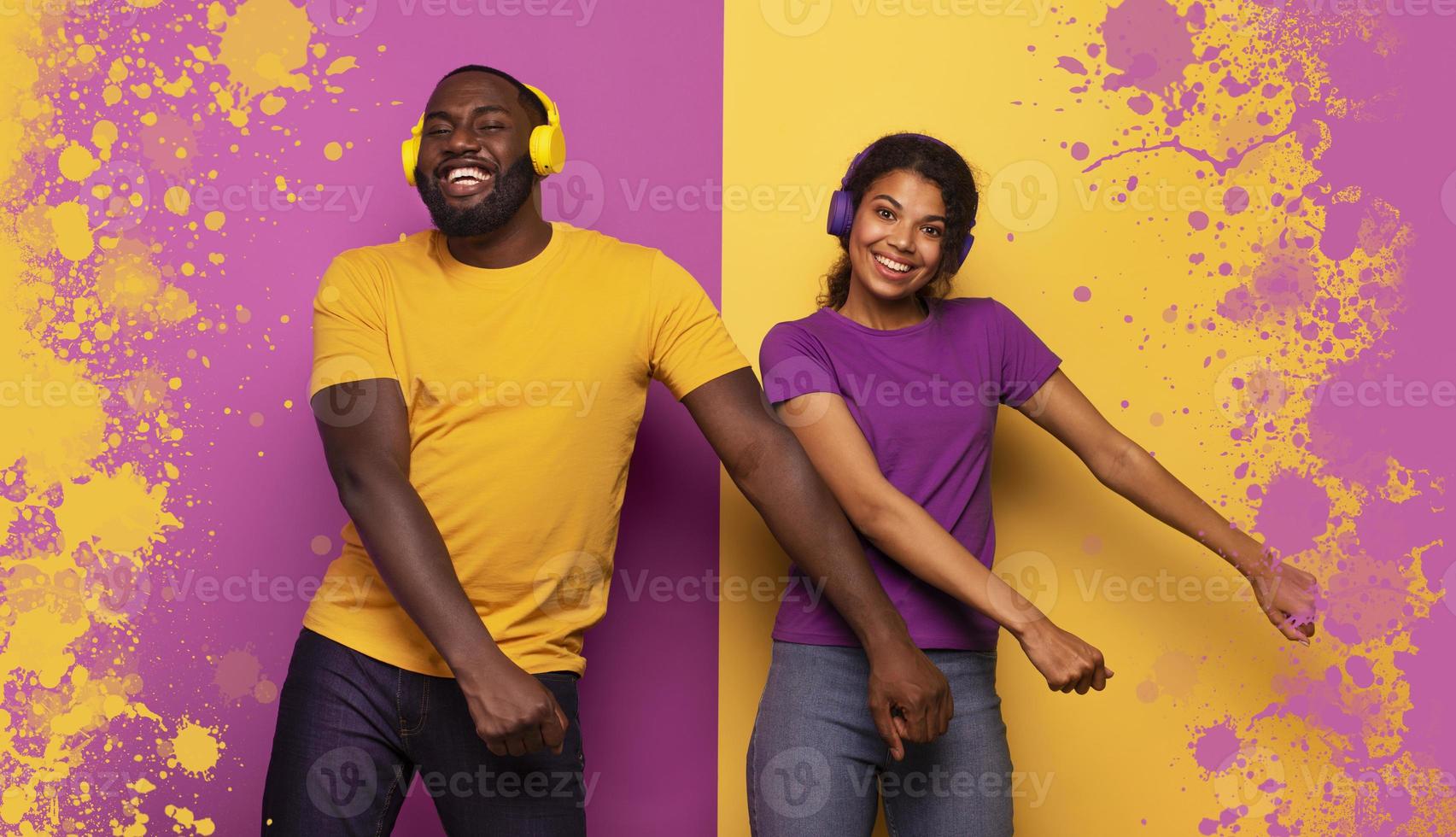 Couple with headset listen to music and dance with energy on violet and yellow background photo