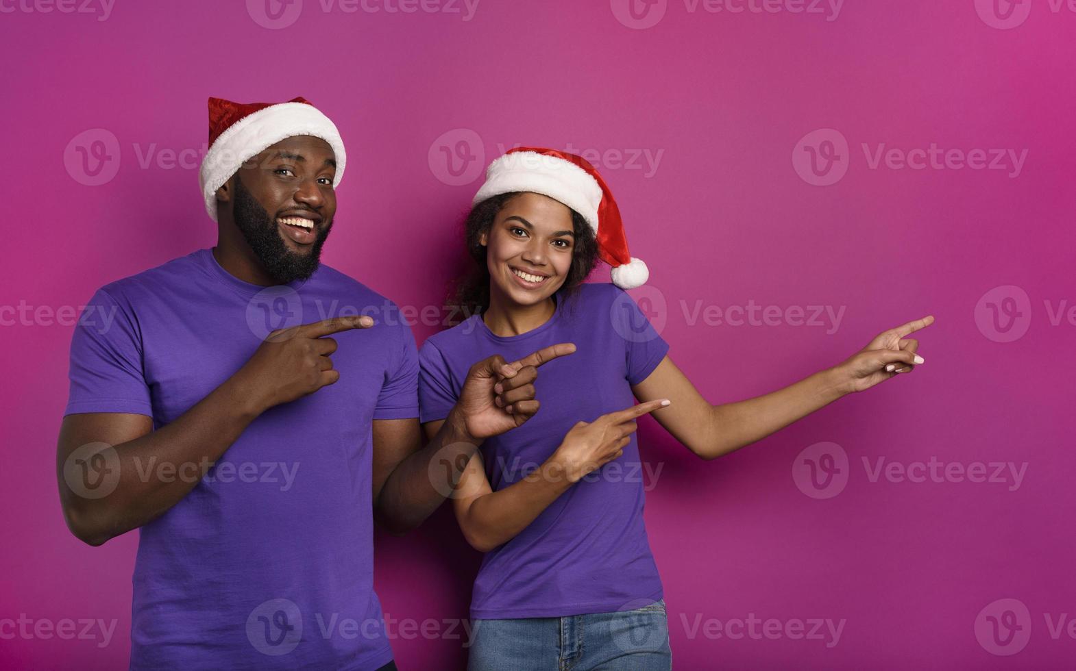 Amazed friends surprised by the arrival of Christmas. Purple background photo