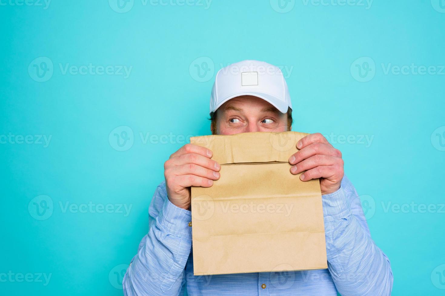 Delivery man hides his face with a food package photo