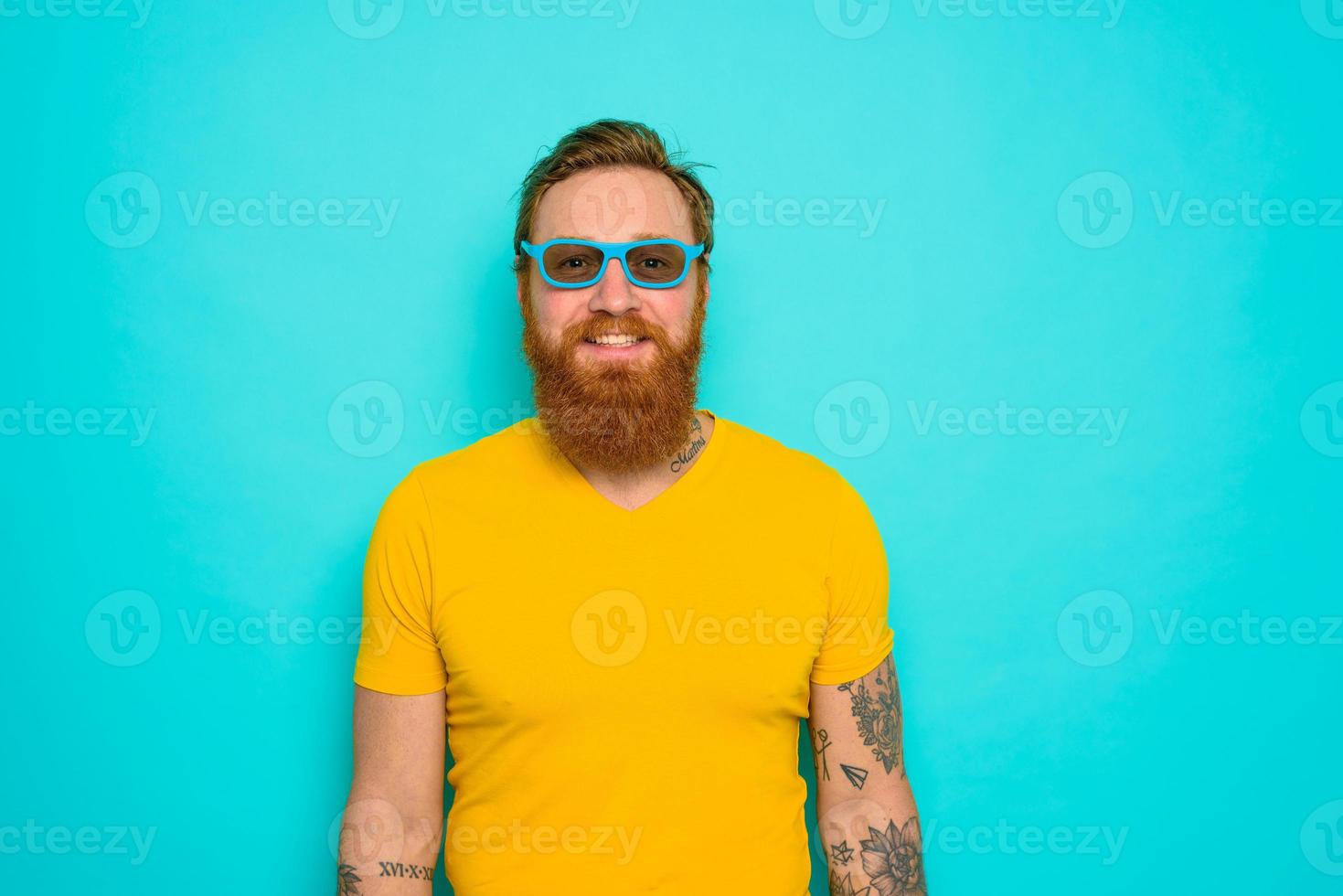 hombre con amarillo camiseta y barba es muy contento foto