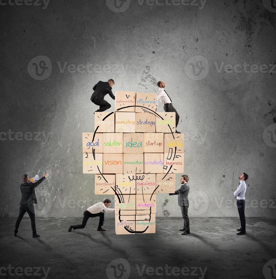 Building a new creative idea. Business person built together a big brick wall with drawn lightbulb photo