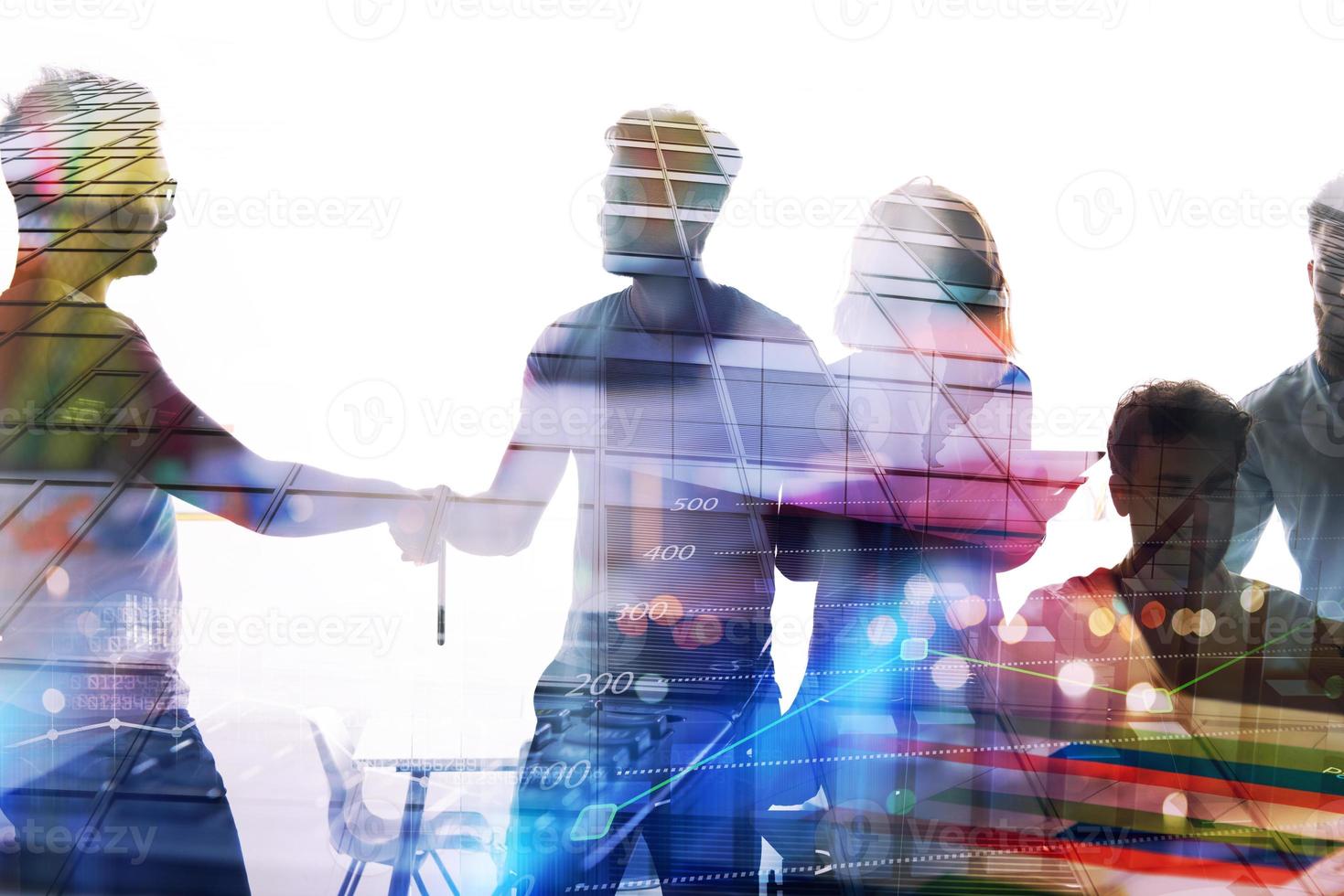 Silhouette of young workers shaking hands in the office. concept of teamwork and partnership. double exposure photo