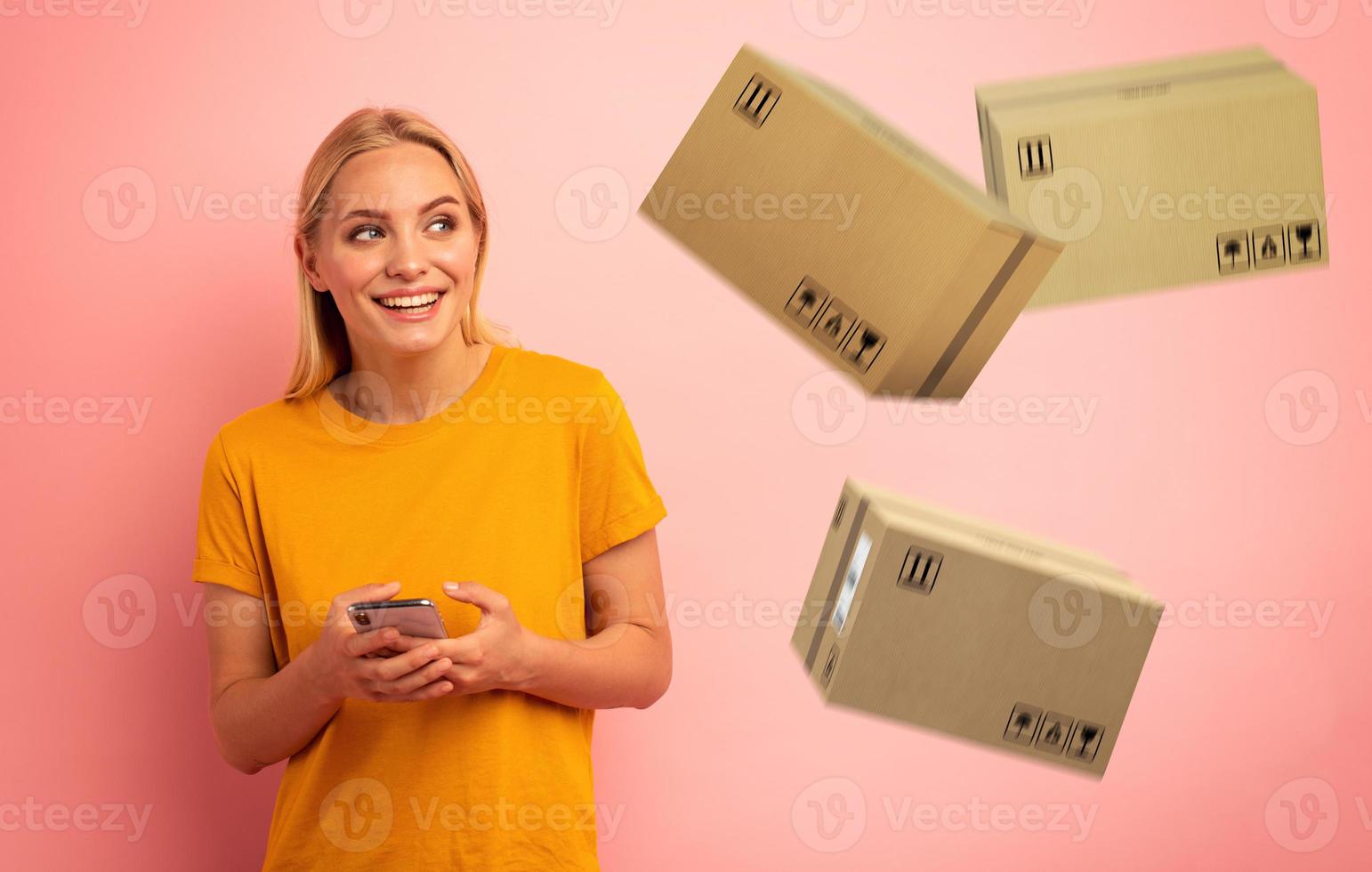 Blonde cute girl receives priority fast boxes from online shop order. Surprised and amazed expression. Pink background photo
