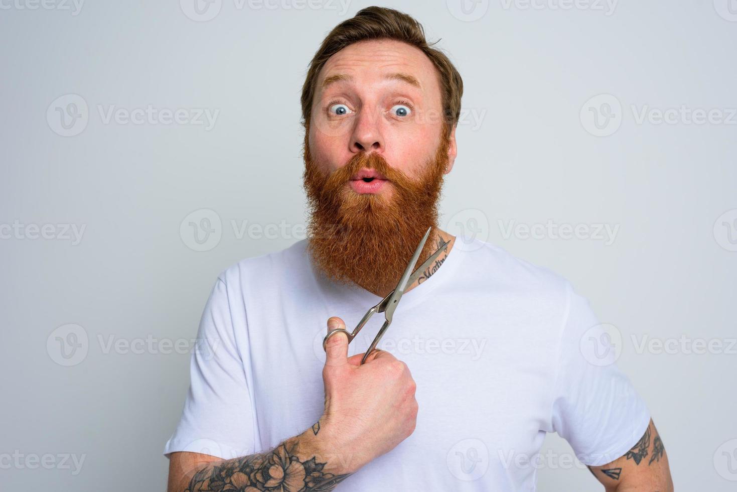 Wondered man with scissors is ready to cut the beard photo