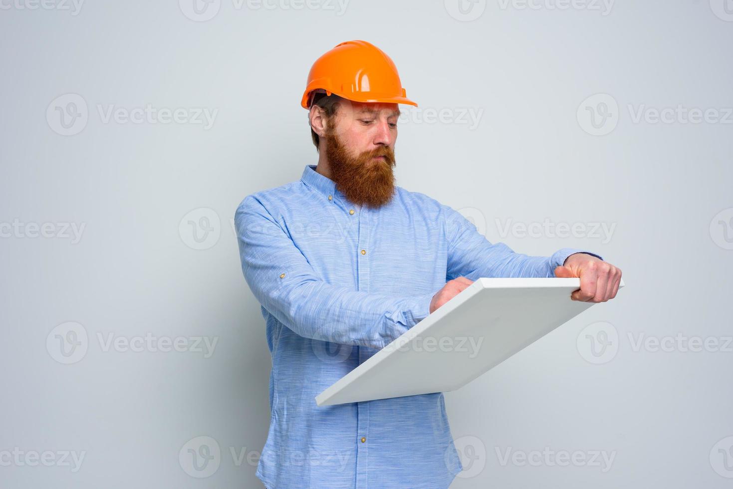 Confidant architect with beard and orange helmet does a sketch photo