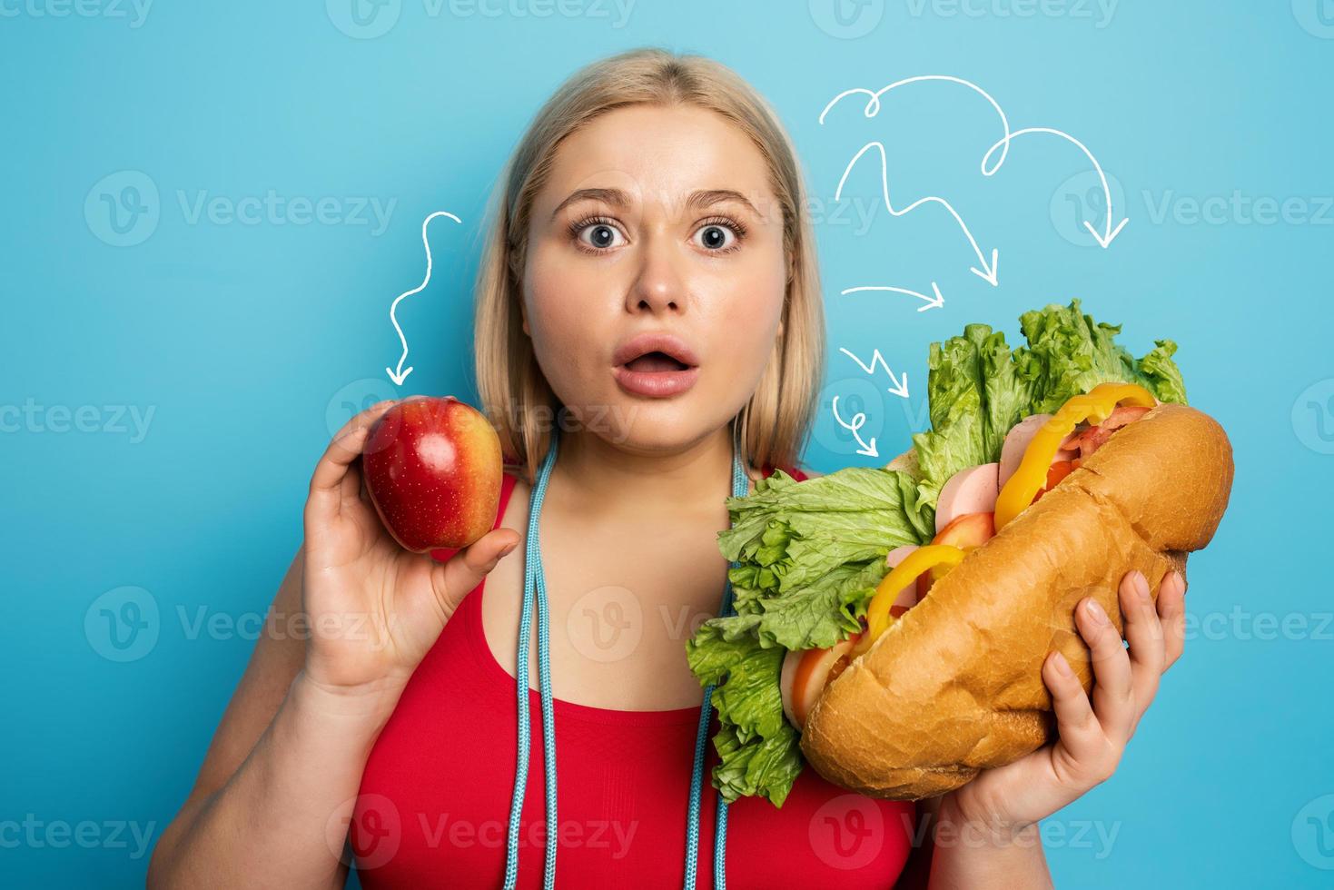 Fat girl does gym and want to eat a sandwich. Concept of indecision and doubt photo
