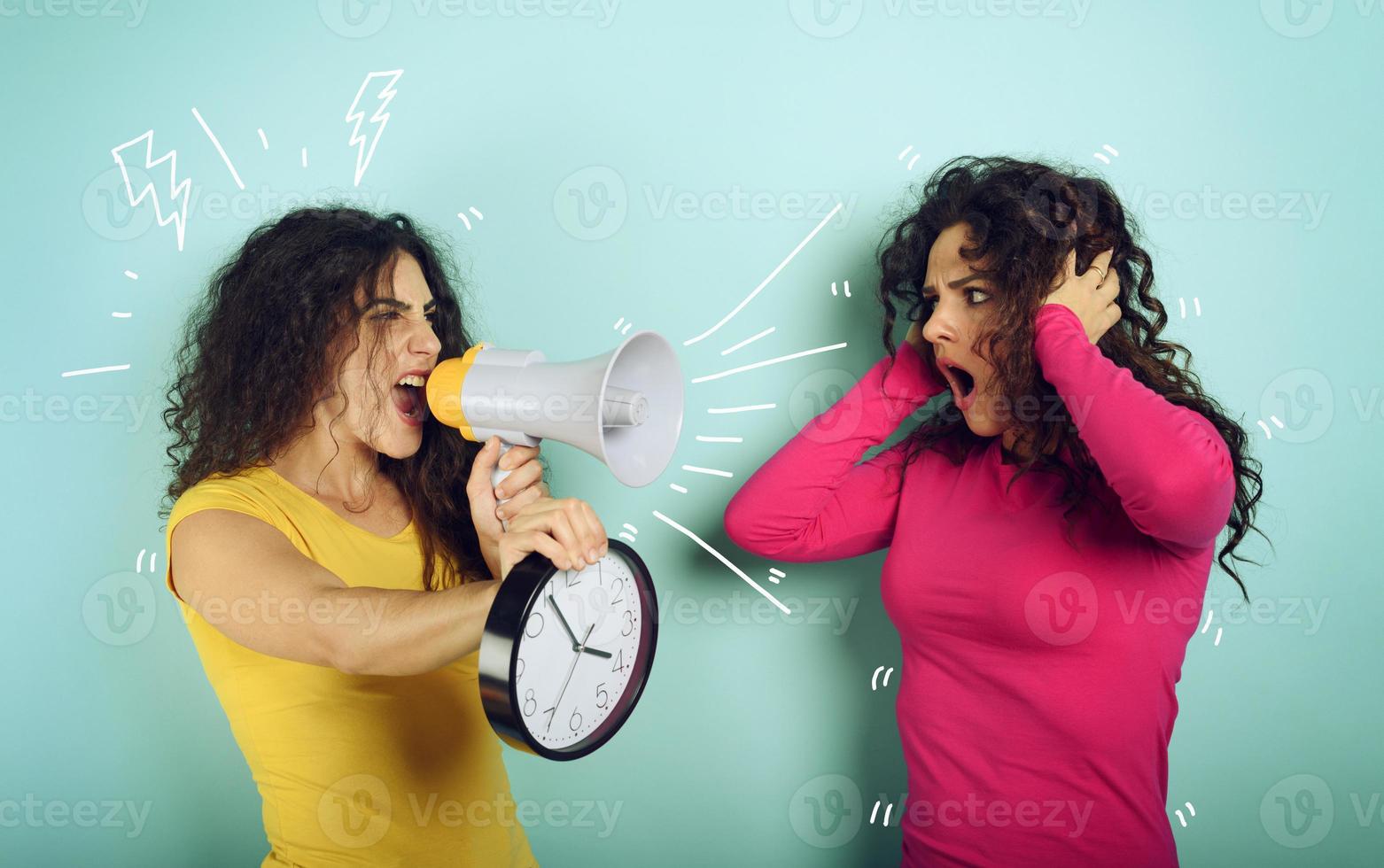 Woman screams with loudspeaker to a friend because is too late. angry expression. cyan background photo