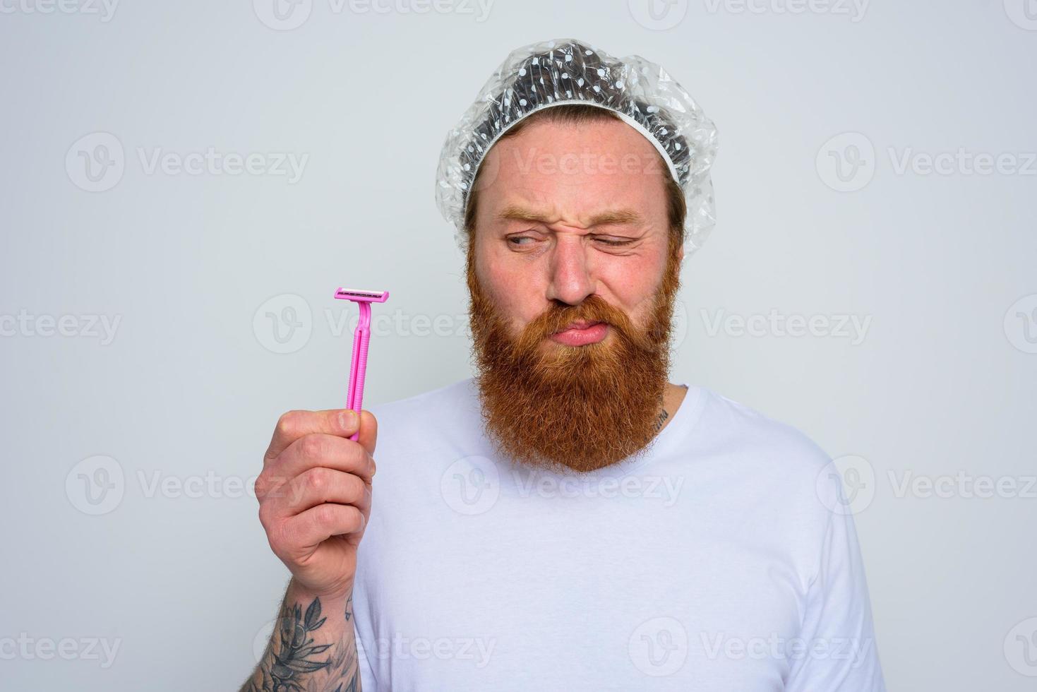 doubter man wants to adjust the beard with a razor blade photo