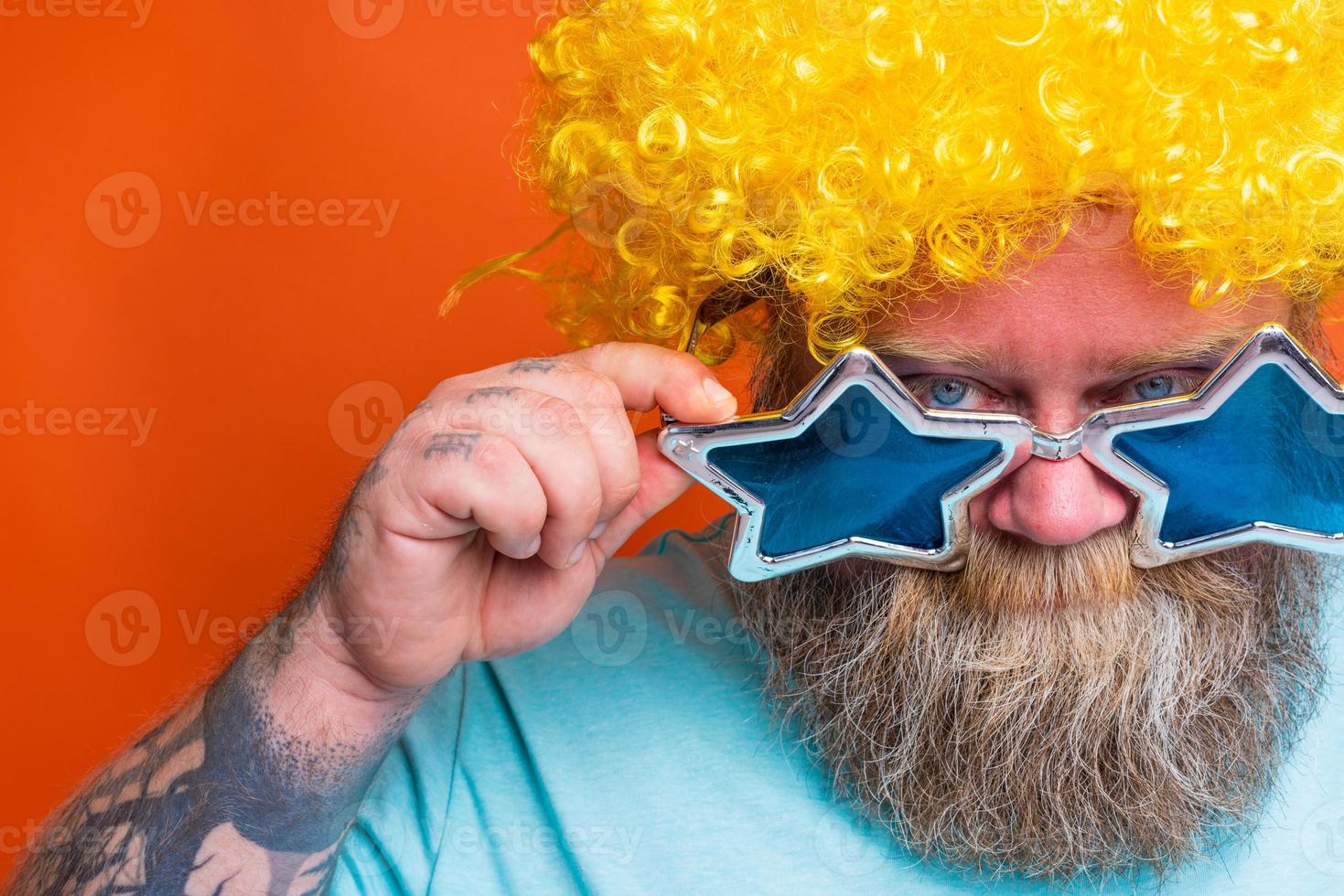 Fat thoughtful man with beard, tattoos and sunglasses has doubt about something photo