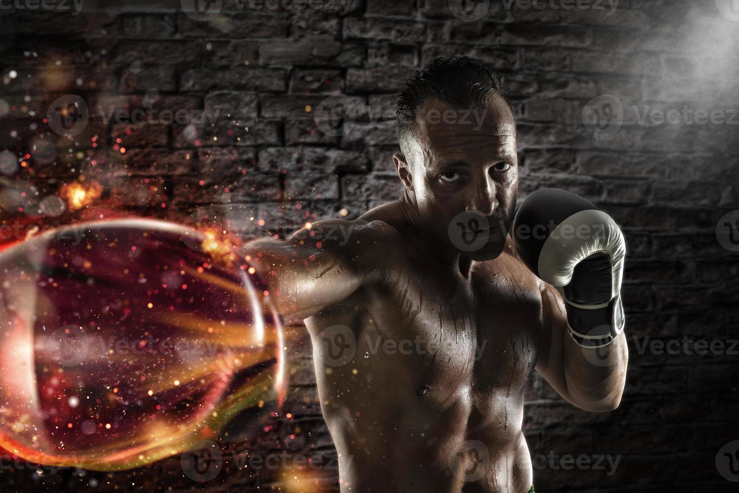 Confident athletic boxer with fiery boxing gloves photo