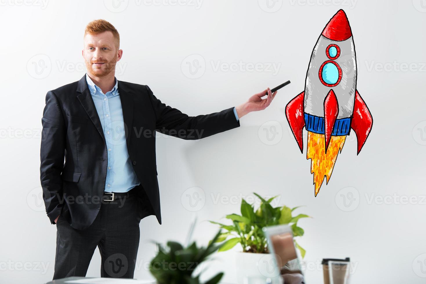 Businessman drawing a rocket. Concept of business improvement and enterprise startup photo