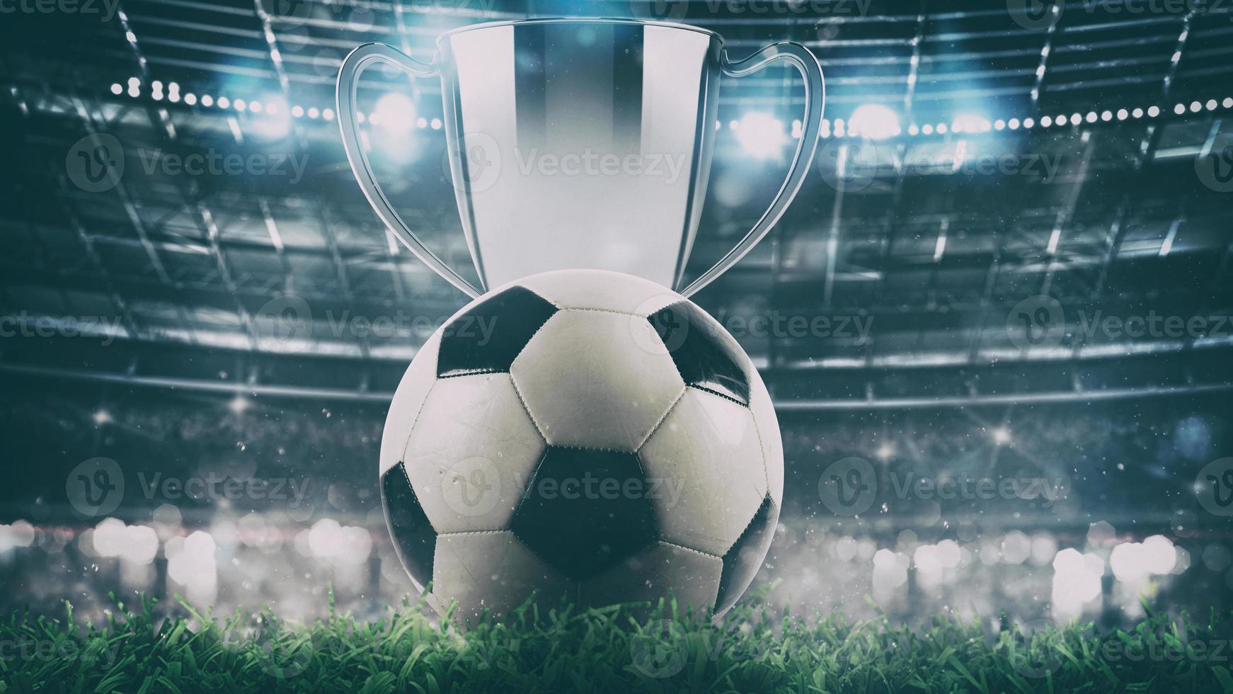 Close up of a soccer ball with trophy in the center of the stadium illuminated by the headlights photo