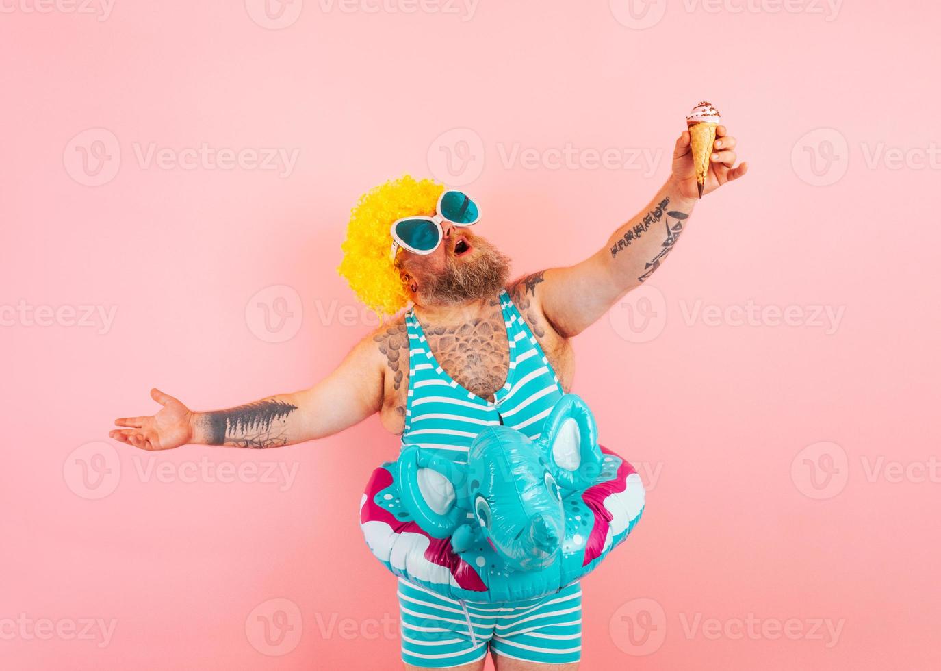 grasa hombre con barba y vida boya para niños come un helado foto