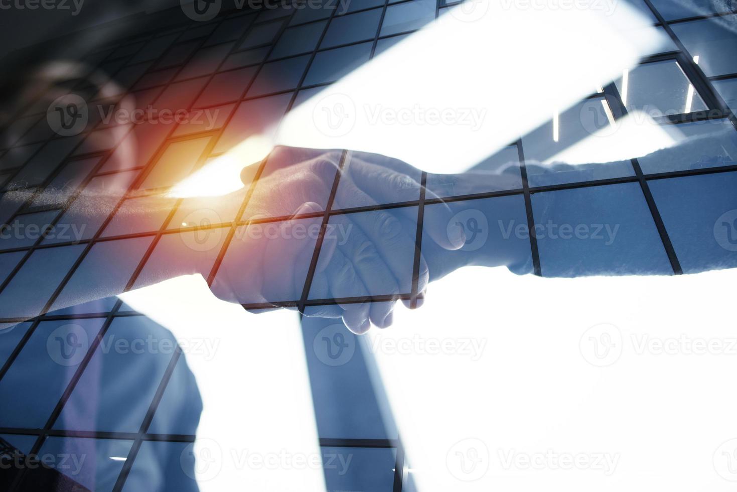 Handshaking business person in office. concept of teamwork and partnership. double exposure photo