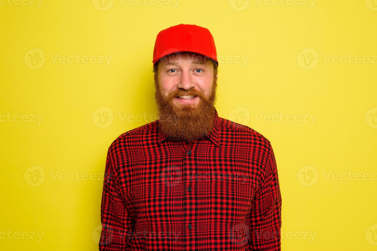 Delivery man with hat and beard has an happy expression photo