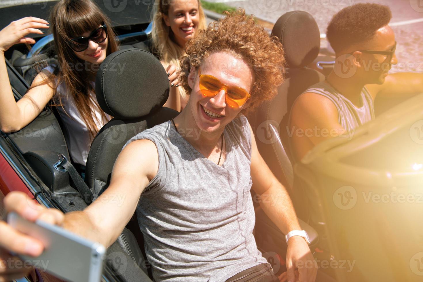 Young friends take a selfie in a cabriolet car photo