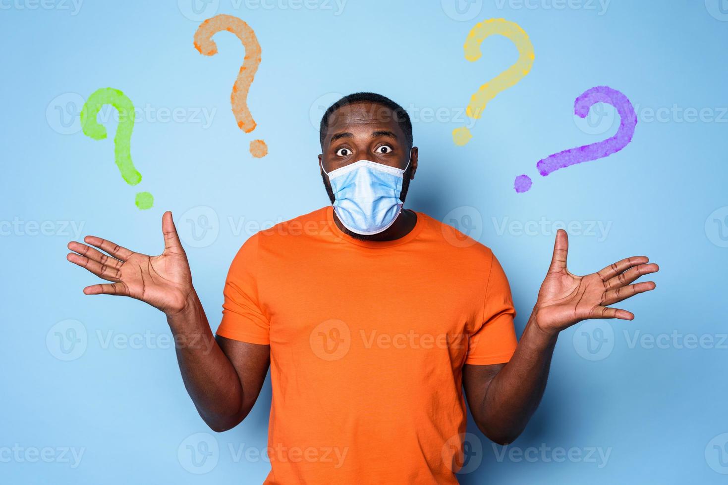 Boy with face mask has a lot of question about covid 19. cyan background photo