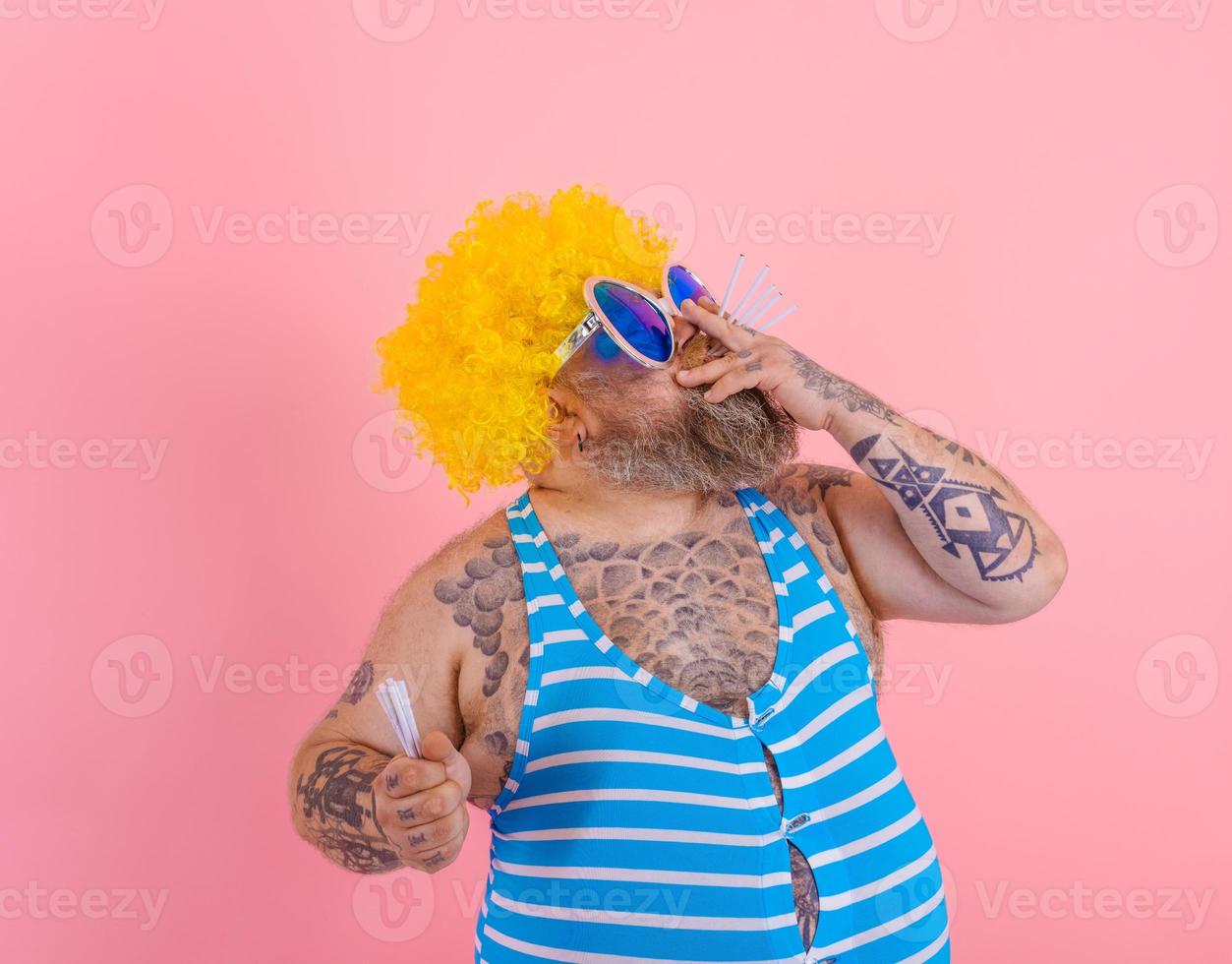 Fat man with beard and wig smokes cigarettes photo