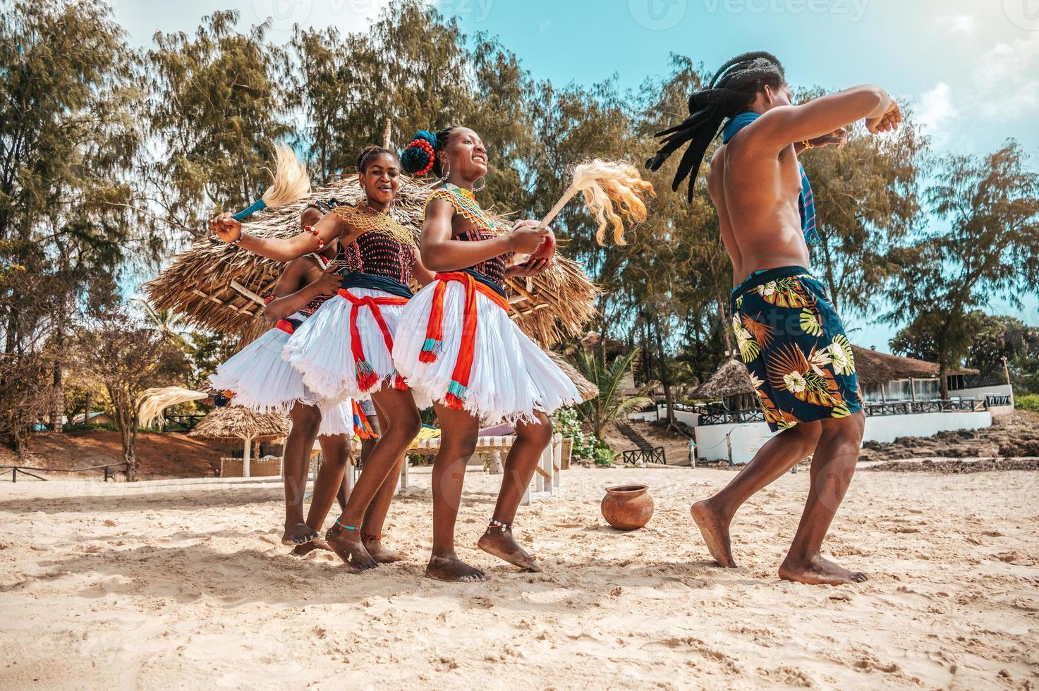 Kenyan people dance on the beach with typical local clothes photo