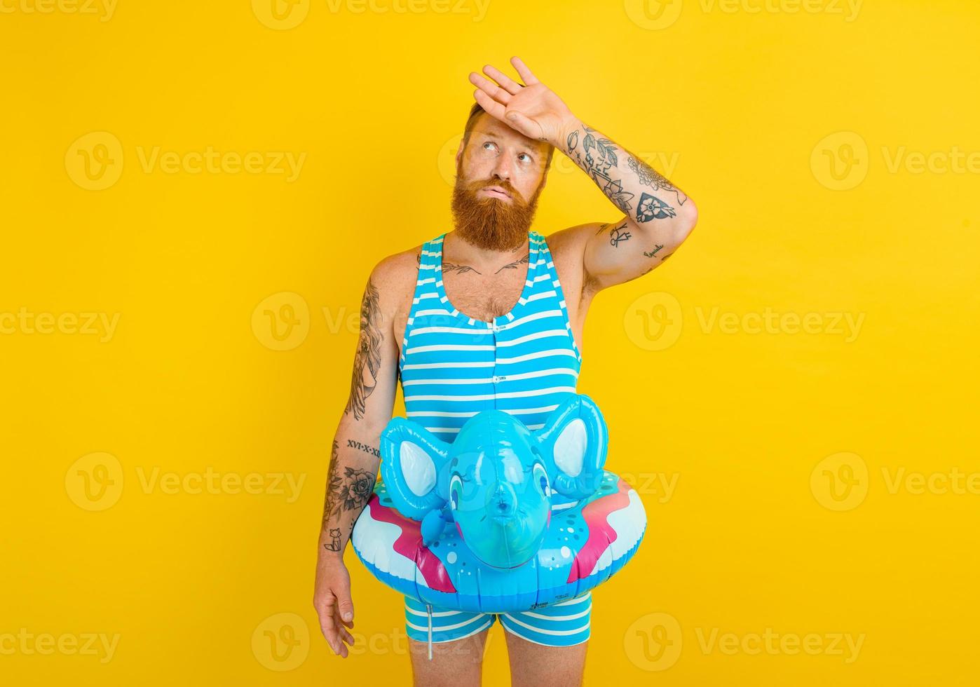 man with inflatable donut with elephant is ready to swim photo