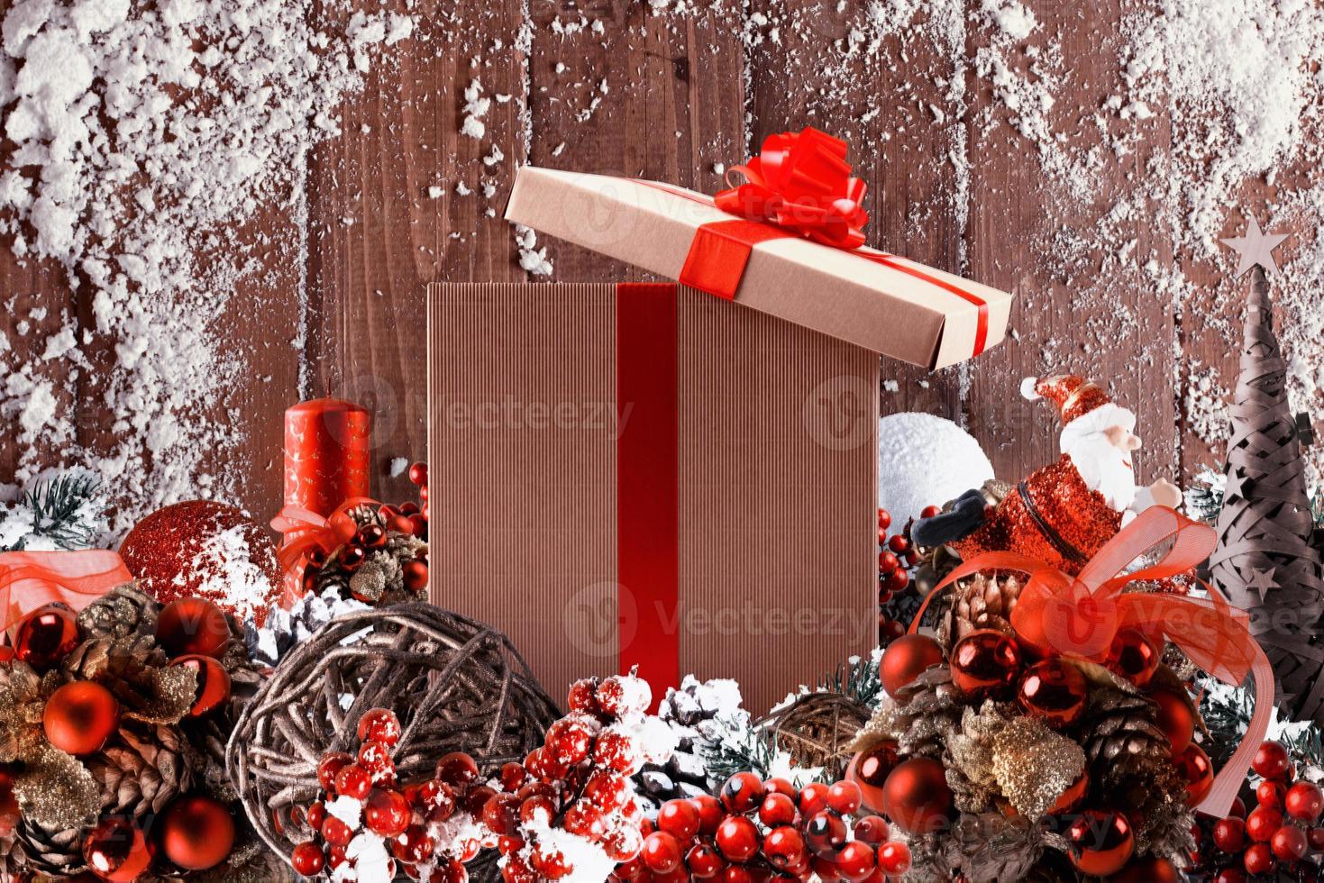 Christmas gift box presented in the middle of Christmas decorations on wooden planks photo