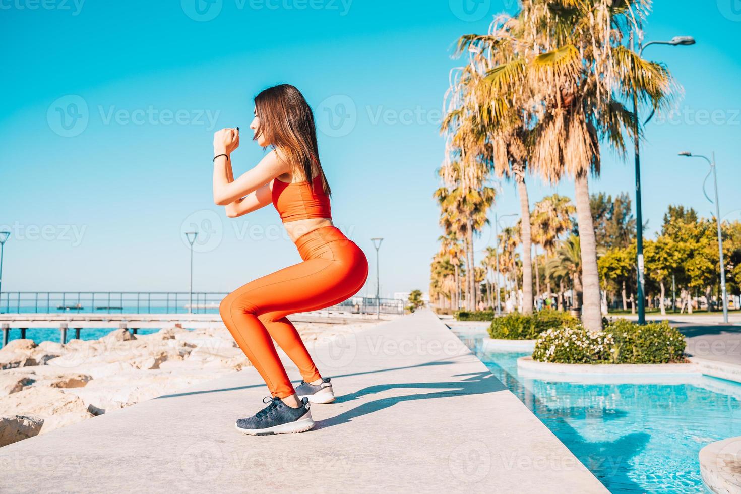 Woman does gym stretching exercises outdoor in a sunny day photo