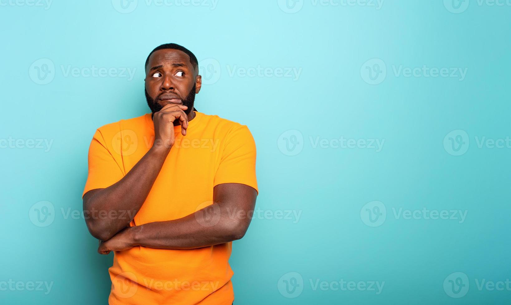 Confuse and pensive expression of a boy . cyan colored background photo