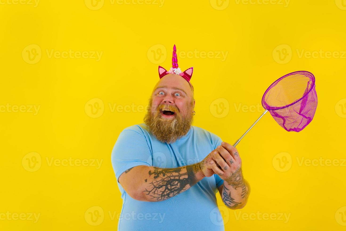 Fat happy man with headband play with sea net photo