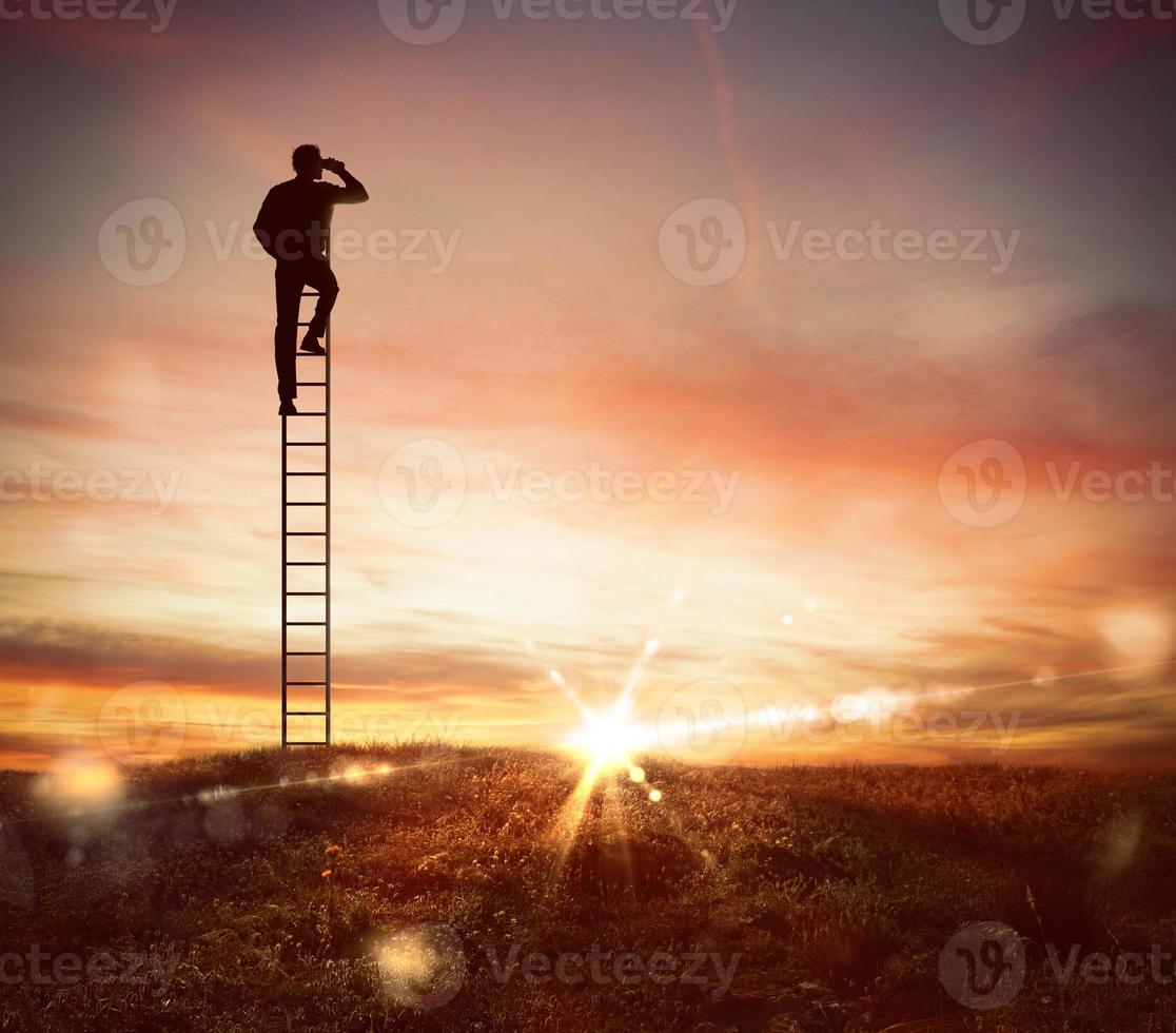 Businessman looks far for new business with binocular photo