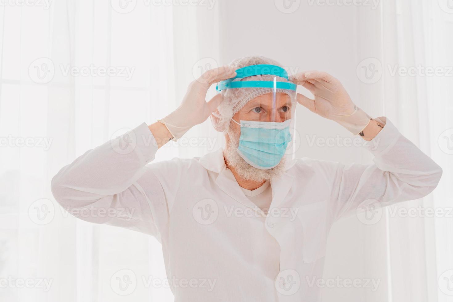 Doctor with mask and face protector is ready to work in hospital photo