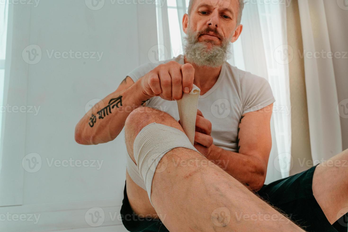 Sportive man applies protective bandage for sport photo