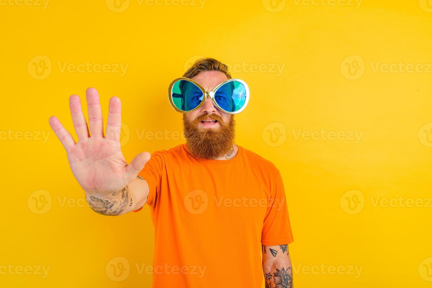 Serious man with beard, tattoo and big sunglasses photo