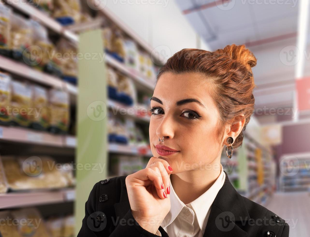 Woman at supermarket thinks about what to buy photo