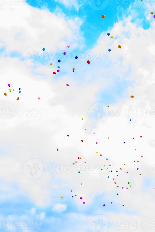 balloons in the sky. many multicolored  balloons launched into the sky photo