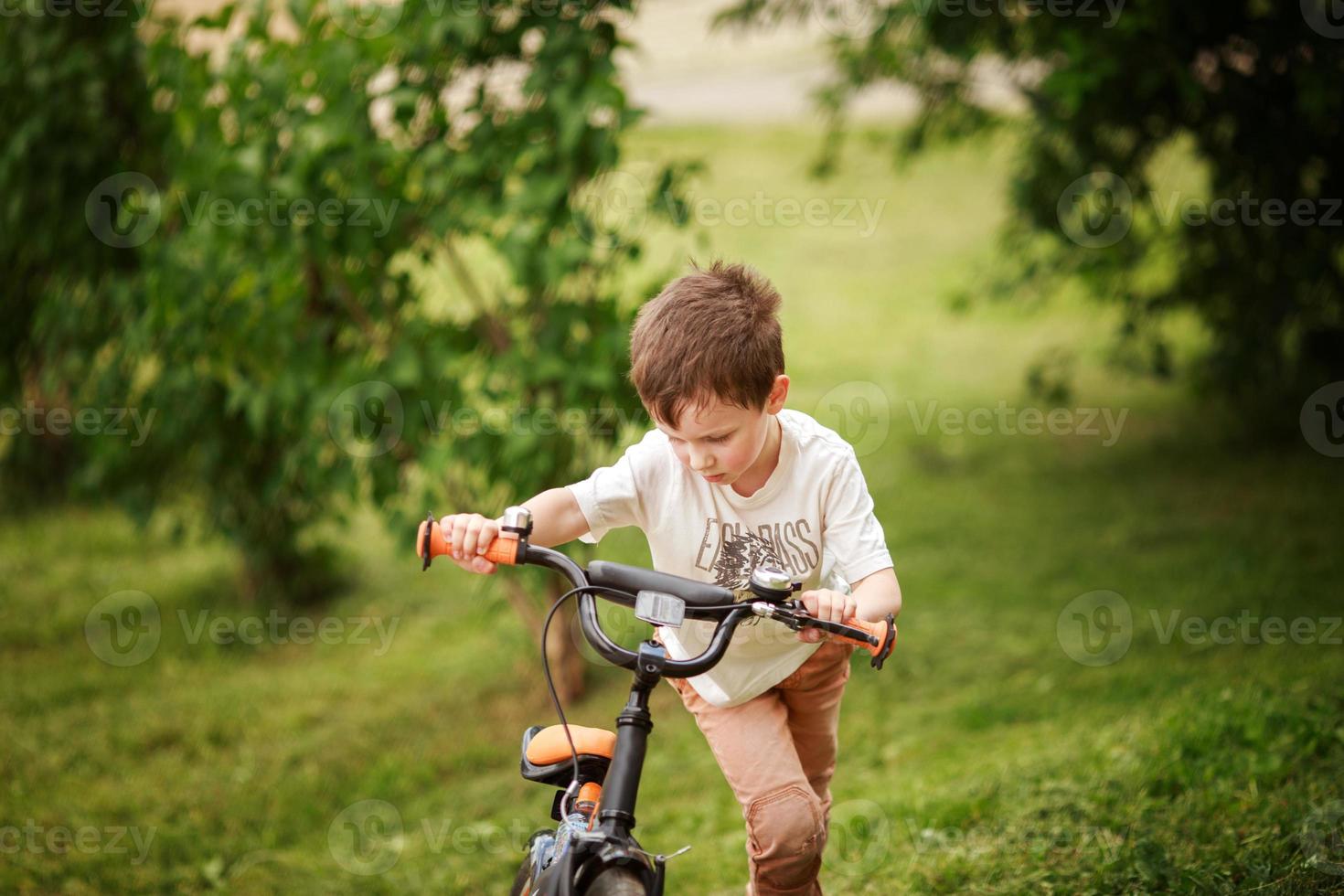 the boy is riding a bike on the street photo